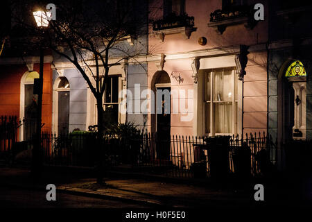 Lamplight éclairante, cette terrasse maisons pastel colorés Logement Londres Angleterre Banque D'Images