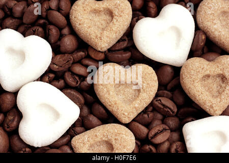 Coeurs de sucre brun et blanc couché sur les grains de café torréfié Banque D'Images