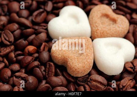 Coeurs de sucre brun et blanc couché sur les grains de café torréfié Banque D'Images