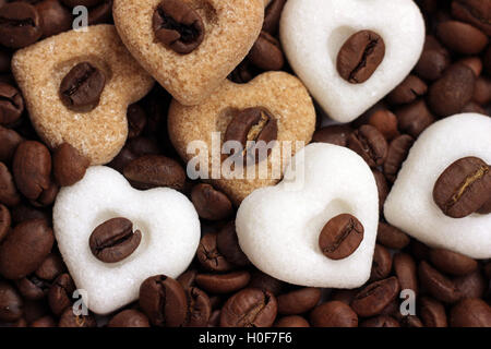 Coeurs de sucre brun et blanc couché sur les grains de café torréfié Banque D'Images