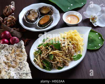 Abalone ayant des tranches de viande et les herbes salade avec craquelins de riz sur plaque blanche dans Vietnam restaurant Banque D'Images