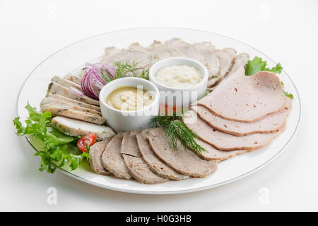 La viande en tranches de jambon du plateau avec des sauces et salades on white plate Banque D'Images