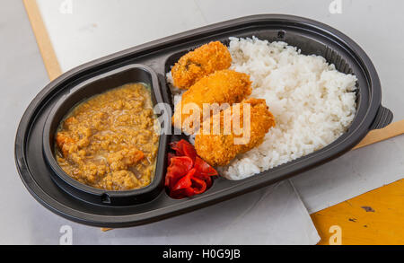 Voler avec curry huîtres tempura frit, piment et le riz ordinaire dans bento box Banque D'Images