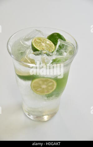 Verre de jus de kumquat vert avec la glace froide sur fond blanc Banque D'Images