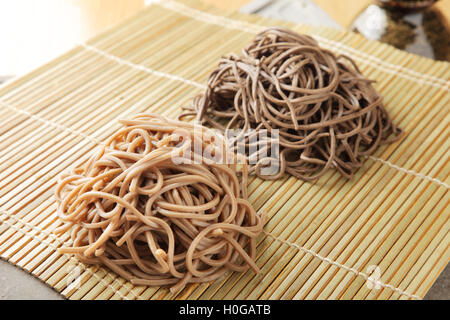 Matières premières nouilles Udon séchées japonais sur bambou plateau en restaurant Banque D'Images