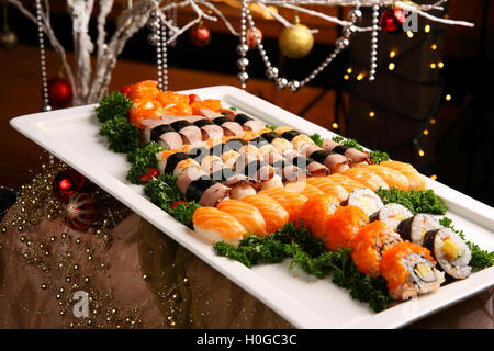 Des sushis fraîchement préparés avec propagation kimbap et saumon sur grand plateau blanc Banque D'Images