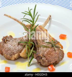 Escalope de porc rôti de côtes avec rosemarry et sauce tomate sur plateau blanc