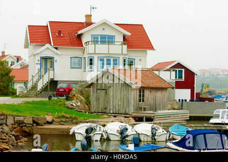 Tjorn, Suède - septembre 9, 2016 : d'un documentaire de l'environnement home côtières avec beaucoup de bateaux et un hangar non peinte à l'avant Banque D'Images