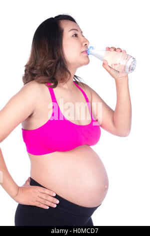 Femme enceinte, boire de l'eau dans une bouteille isolé sur fond blanc Banque D'Images