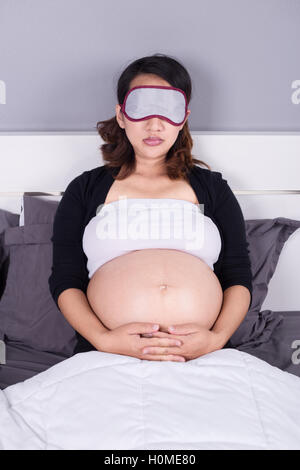 Pregnant woman sleeping on lit dans la chambre à coucher à la maison Banque D'Images