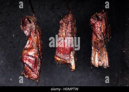 Fumeurs pendu au cou de porc de façon traditionnelle dans le fumoir d'accueil, en République tchèque. viande très savoureux aromatisés et gar Banque D'Images