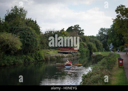 Une famille ramer un bateau le long du canal à Chichester Chichester, West Sussex, Angleterre. Banque D'Images