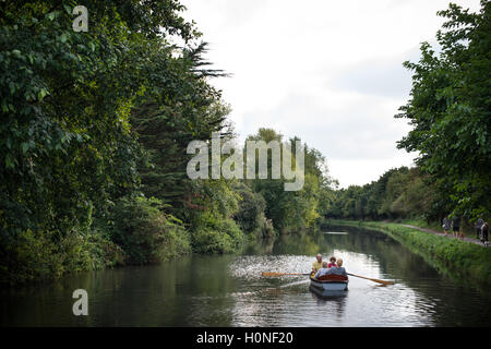 Une famille ramer un bateau le long du canal à Chichester Chichester, West Sussex, Angleterre. Banque D'Images