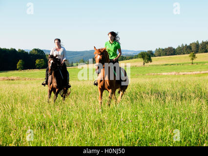 Deux femmes l'équitation dans un paysage Banque D'Images