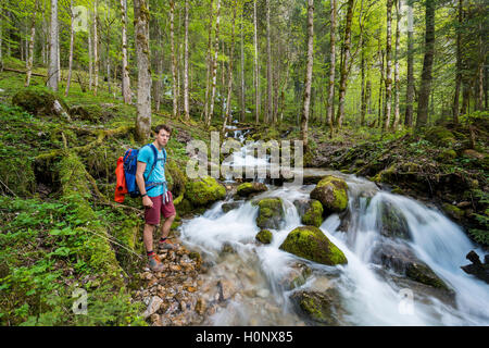 Jeune homme près d'une crique, Röthbach, avec la mousse, à la fin de la rivière Cascade, Röthbach Salet am Königssee Banque D'Images