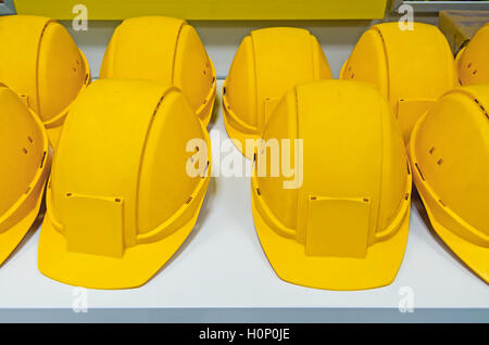 Casques de protection jaune sur le banc prêt à les récupérer pour les travailleurs Banque D'Images