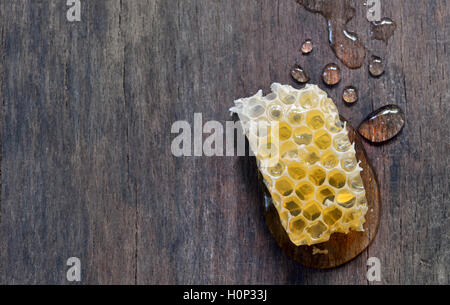 Miel sucré avec miel isolé sur fond de bois vieux Banque D'Images