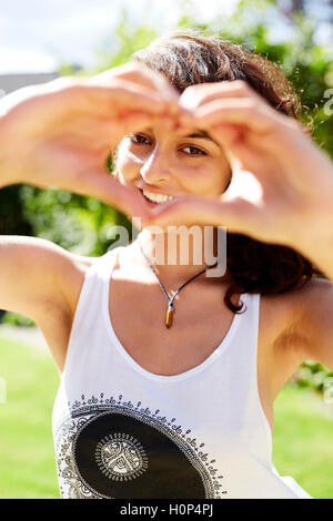 Girl making heart shape with hands Banque D'Images
