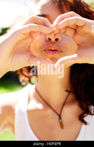 Girl making heart shape with hands Banque D'Images