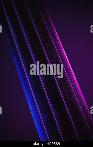 Studio de la composition d'un vieux violon poussiéreux, bleu et violet à partir de l'éclairage de côté, vue rapprochée sur le cou et des chaînes. Banque D'Images
