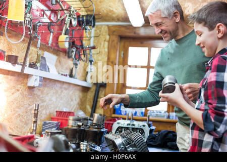 Père Fils l'examen de la partie voiture auto repair shop Banque D'Images