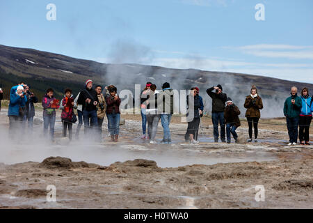 Les touristes restent là à attendre le strokkur geysir geyser en éruption en Islande Banque D'Images