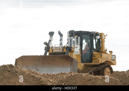 Bulldozer poussant la boue pour créer un mur autour d'une nouvelle mine. Avec la centrale électrique de KingsNorth en arrière-plan pendant la phase de démolition. Banque D'Images