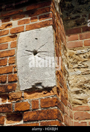 Cadran solaire en pierre médiévale ou masse cadran serti dans un contrefort à côté du portique de l'église de St Andrew, Ashingdon, Essex, Angleterre Banque D'Images