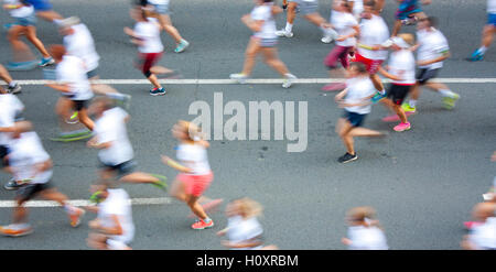 Les gens en blanc T-shirts running semi marathon dans les rues de la ville à l'effet de flou de l'attention Banque D'Images