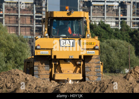 Bulldozer poussant la boue pour créer un mur autour d'une nouvelle mine. Avec la centrale électrique de KingsNorth en arrière-plan pendant la phase de démolition. Banque D'Images