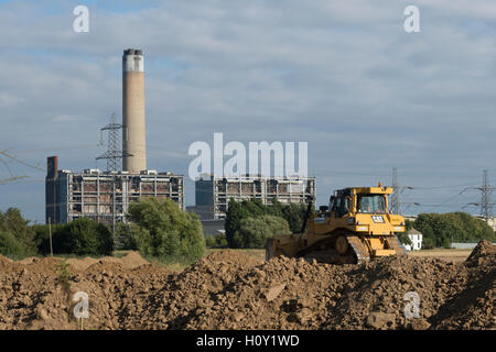 Bulldozer poussant la boue pour créer un mur autour d'une nouvelle mine. Avec la centrale électrique de KingsNorth en arrière-plan pendant la phase de démolition. Banque D'Images