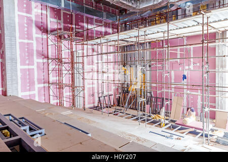 Échafaudage vide est placé contre le mur en placoplâtre à nouveau théâtre avec rétroéclairage de l'extérieur. Banque D'Images