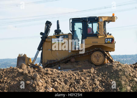 Bulldozer poussant la boue pour créer un mur autour d'une nouvelle mine. Banque D'Images