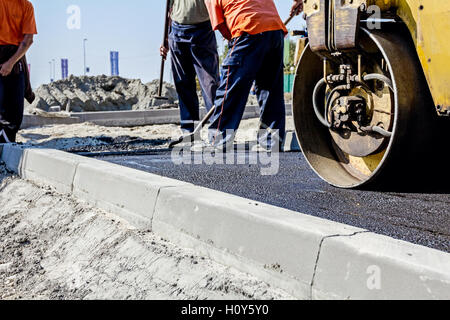 Petit rouleau compresseur est grip nouvelle route asphaltées. Détail sur l'installation d'un trottoir. Plan rapproché sur la route. Banque D'Images