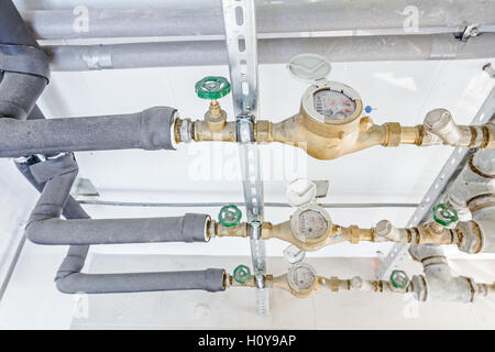 Les compteurs d'eau et les soupapes dans la mesure de la place, sol carrelé avec carrelage blanc. Banque D'Images