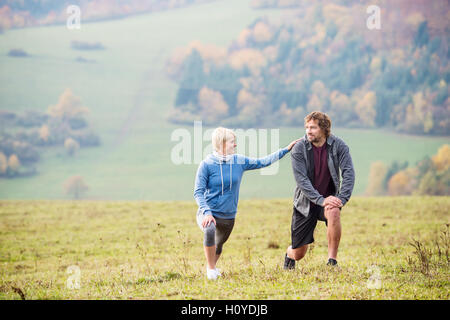 Deux jeunes belle ossature en automne la nature, l'étirement des jambes Banque D'Images