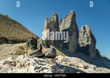 Bottes pour les montagnes pour la randonnée sur l'arrière-plan de la région des Dolomites Tre Cimme, Italie. Des chaussures de randonnée d'un randonneur sur un rocher Banque D'Images