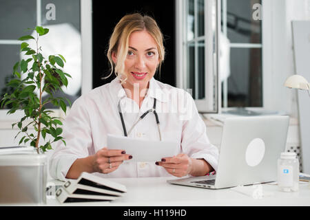 Mid adult female doctor lire des documents Office Banque D'Images