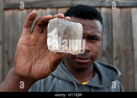 Cristal de roche holding travailleur ( c.-à-quartz hyalin) trouvés dans une carrière voisine ( Madagascar) Banque D'Images