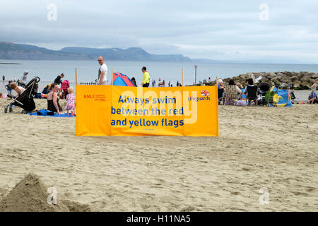 La sécurité de la RNLI bannière sur la plage en été à Lyme Regis, dans le Dorset, Angleterre Royaume-uni KATHY DEWITT Banque D'Images