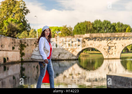 Rimini, Italie, femme marche sur le quai du canal de port près de l'ancien pont romain Banque D'Images