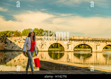 Rimini, Italie, femme marche sur le quai du canal de port près de l'ancien pont romain Banque D'Images