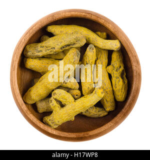 Les rhizomes de curcuma transformés dans un bol en bois sur fond blanc. Curcuma longa, également appelé curcuma. Banque D'Images