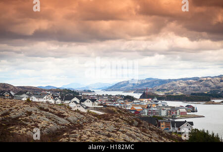 Paysage norvégien côtières. Village de pêcheurs aux maisons colorées sous spectaculaire de couleur ciel nuageux. Rorvik, Norvège Banque D'Images