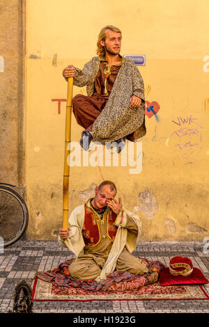 Les artistes de rue à Prague, République tchèque. Un artiste semble soulever sa partenaire dans l'air à l'aide d'une perche de bambou. Banque D'Images