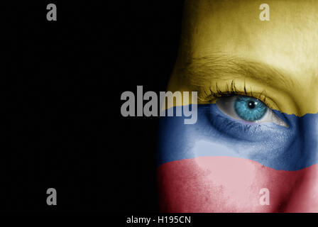 Une jeune femme avec le drapeau de la Colombie a peint sur son visage sur son chemin à un événement sportif pour montrer son soutien. Banque D'Images