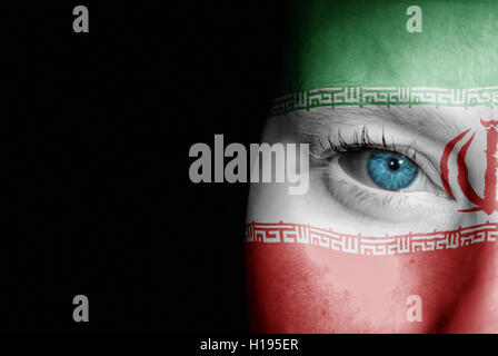 Une jeune femme avec le drapeau d'Iran peint sur son visage sur son chemin à un événement sportif pour montrer son soutien. Banque D'Images