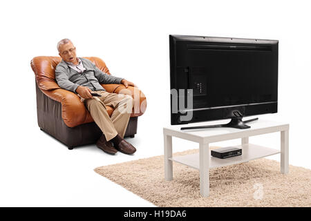 Homme mûr de dormir devant la télévision et la tenue d'un remote isolé sur fond blanc Banque D'Images
