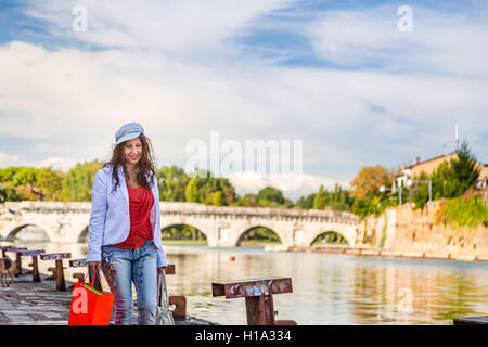 Rimini, Italie, femme marche sur le quai du canal de port près de l'ancien pont romain Banque D'Images