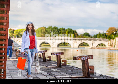 Rimini, Italie, femme marche sur le quai du canal de port près de l'ancien pont romain Banque D'Images